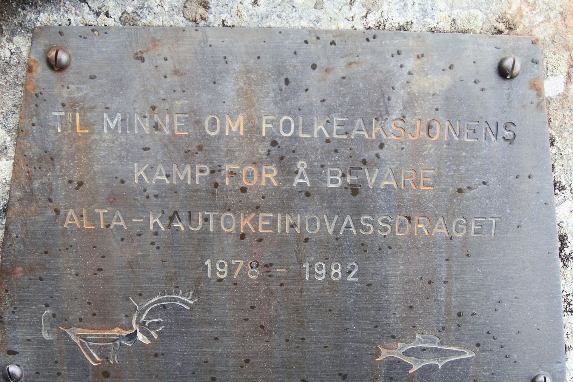 En metallplate hvor det står "Til minne om folkeaksjonens kamp for å bevare Alta-Kautokeinovassdraget, 1978-1982"
