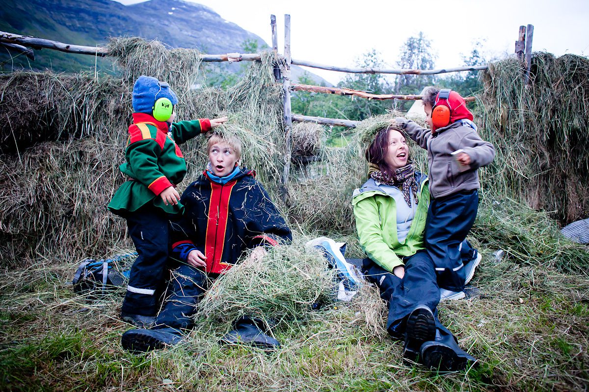 To voksne sitter mens to barn med hørselsvern legger høy på hodet deres